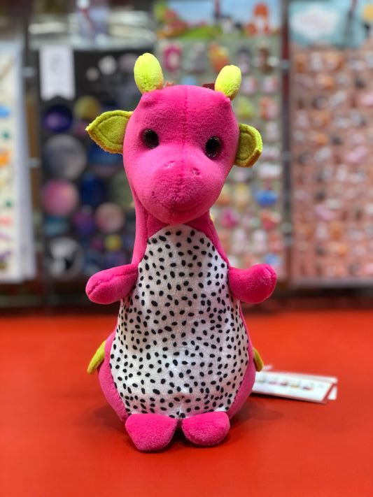 Cute dragon fruit plush toy with bright pink body, yellow-green accents, and speckled white belly, sitting on red surface