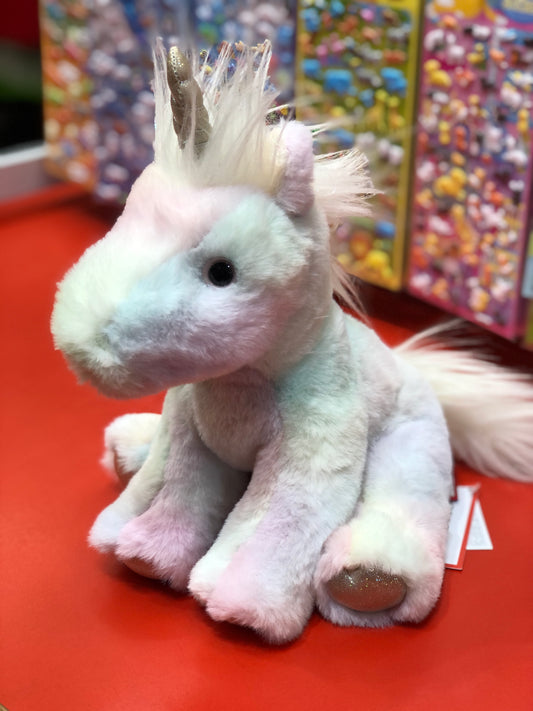 Soft rainbow unicorn plush toy with pastel colors, fluffy mane, and shimmery accents, sitting on red surface