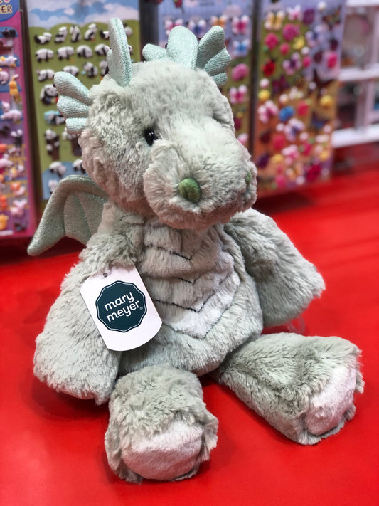 Soft plush Mary Meyer Marshmallow Zoo dragon toy with mint spikes, displayed on red surface with colorful toy background