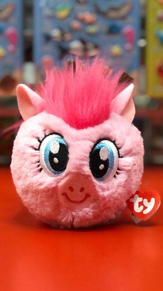 Pink plush toy with a mohawk on a red surface, featuring the Ty brand.