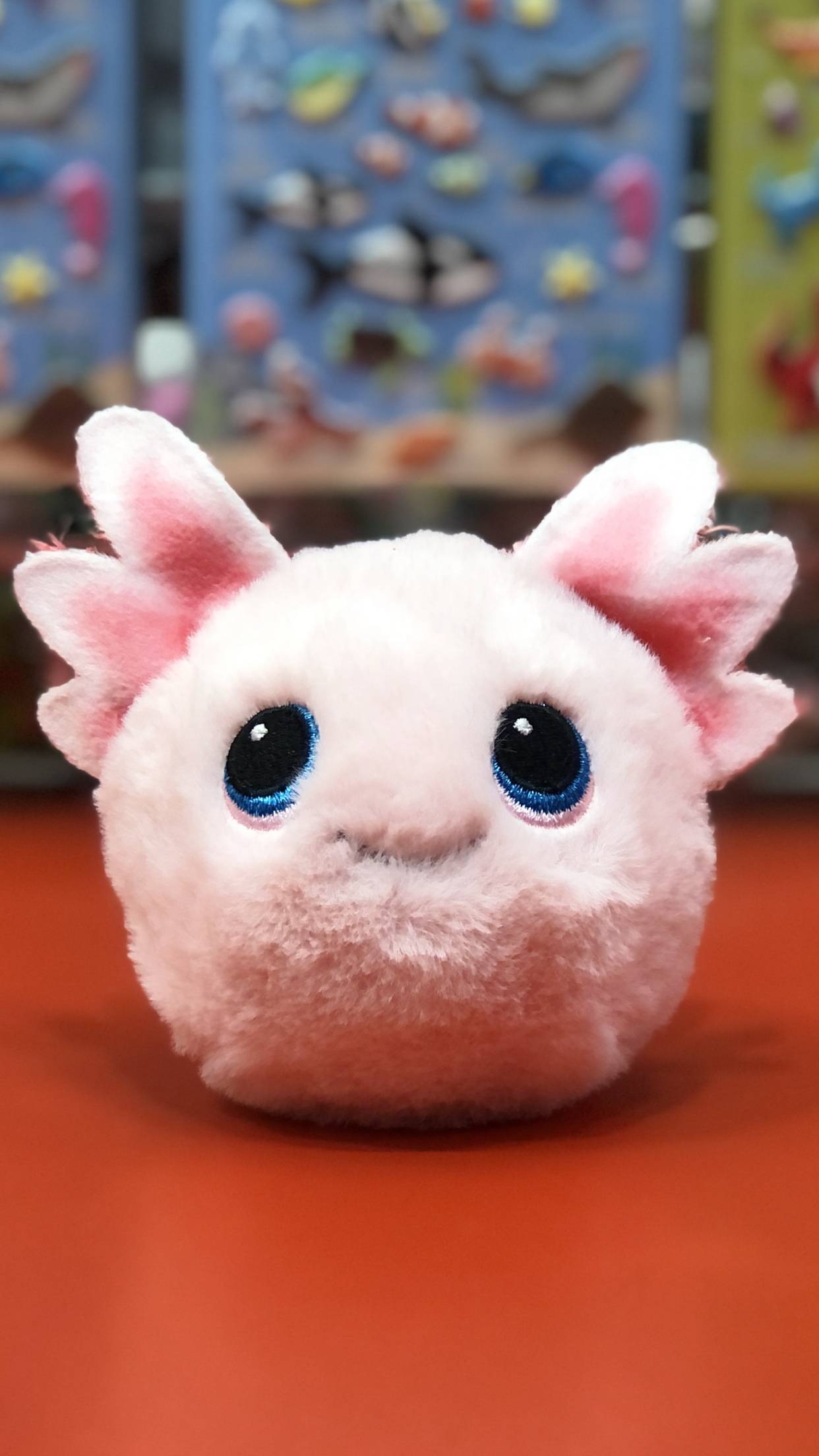 Ty plush toy with large eyes and pink ears on a red surface.