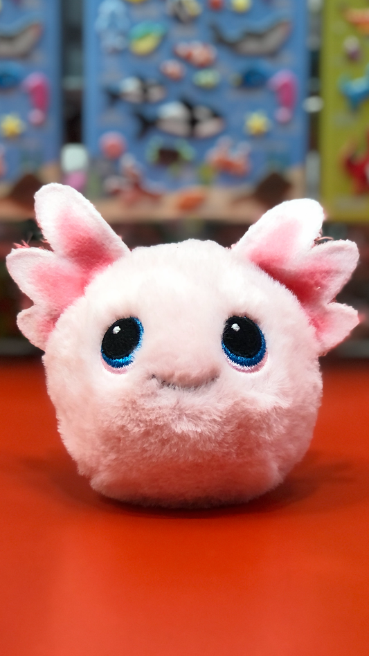 Ty plush toy with large eyes and pink ears on a red surface.