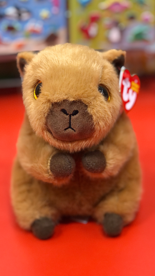 Ty capybara stuffed animal toy with a Ty red tag on a red background.