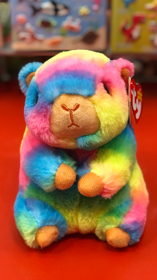 Ty rainbow capybara plush on a red surface. 