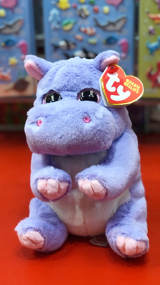 Ty purple plush hippo with a visible brand tag on a red surface. 