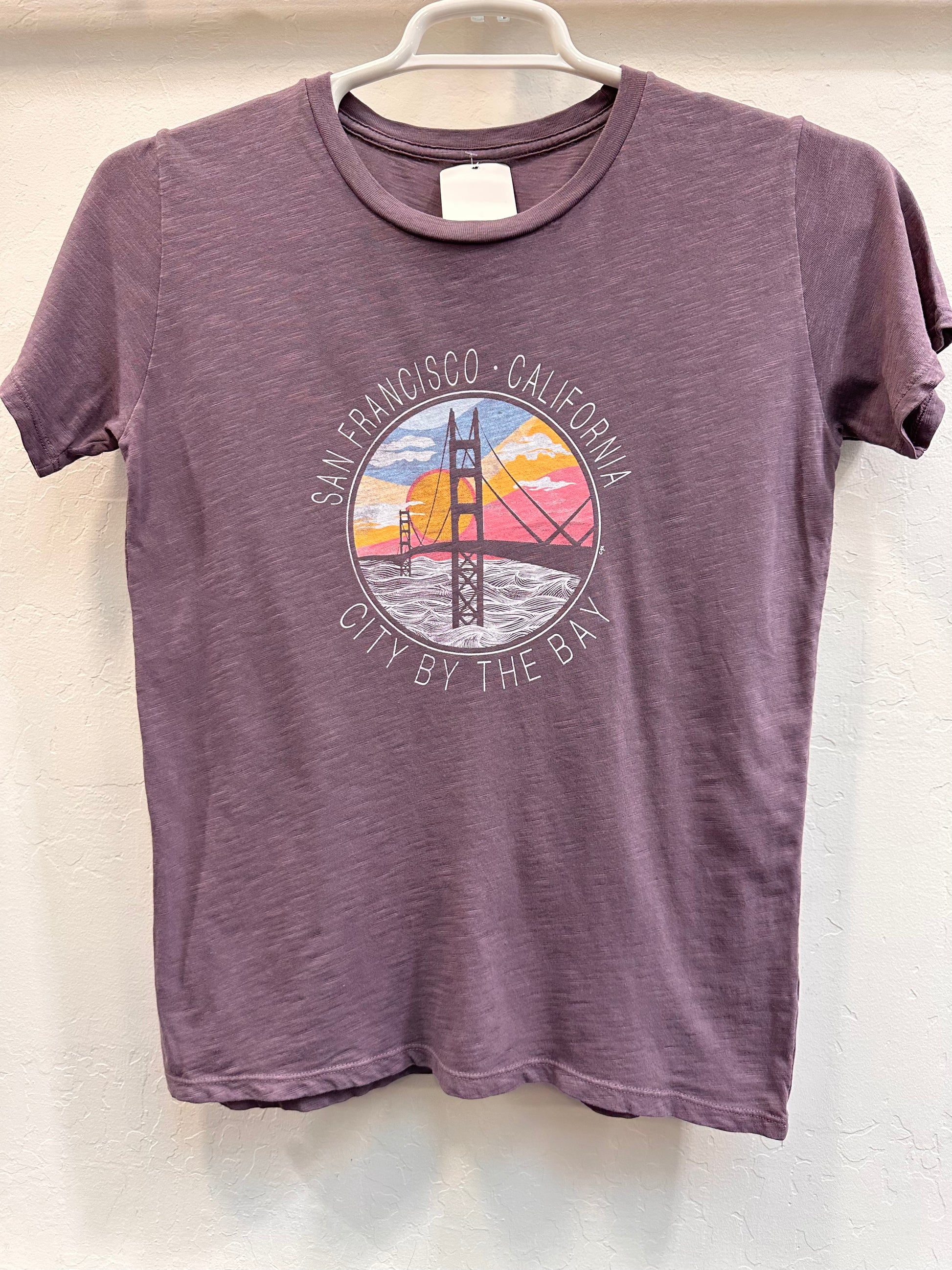 he radiant sun behind the Golden Gate Bridge with the San Francisco Bay below is  printed on a 100% cotton garment dyed shirt.   Material will become soft with repeated washes.  Comes in sizes small to extra large. 