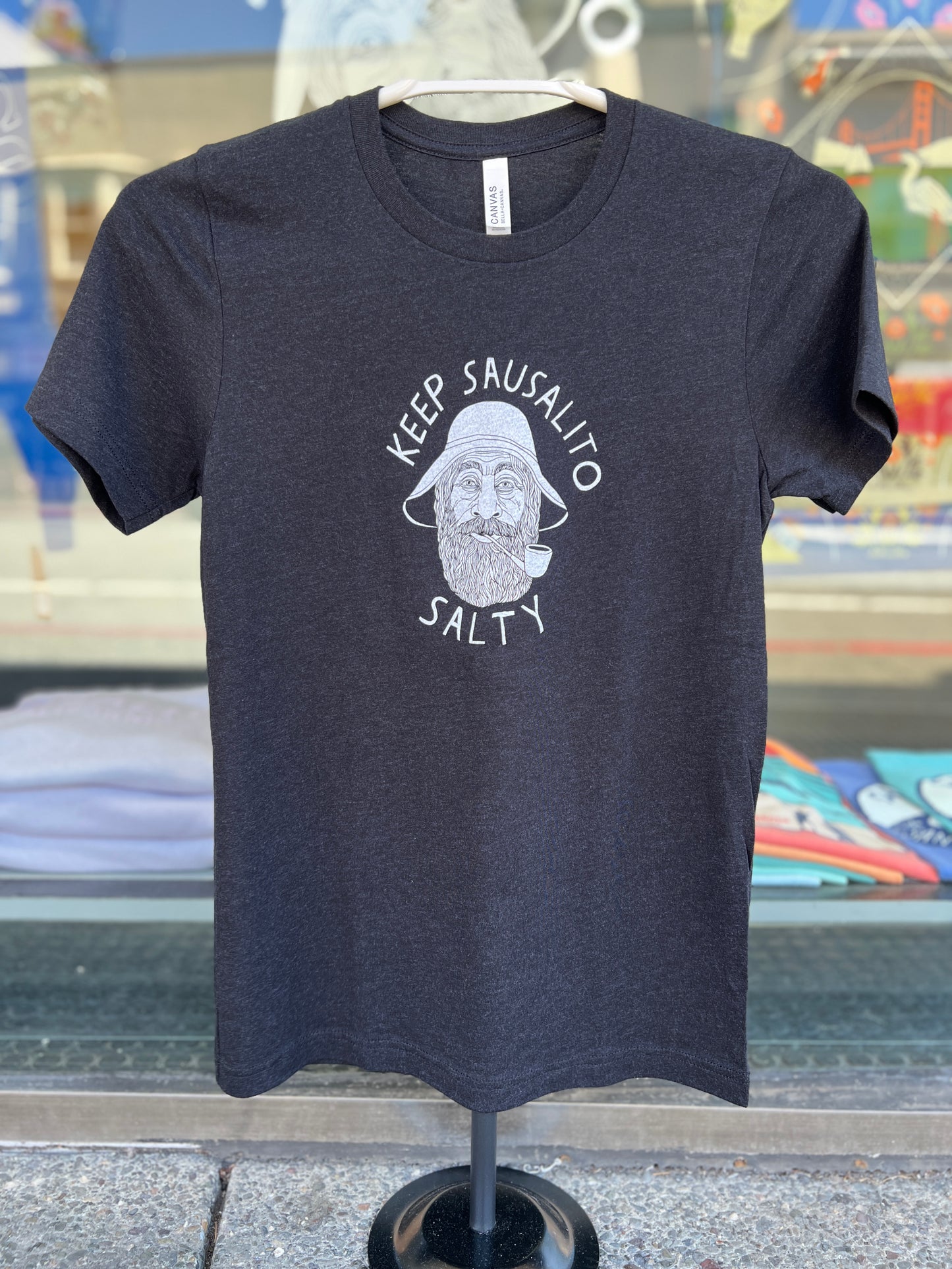 Black t-shirt with "Keep Sausalito Salty" slogan and illustration of bearded man in hat, promoting local charm of Sausalito