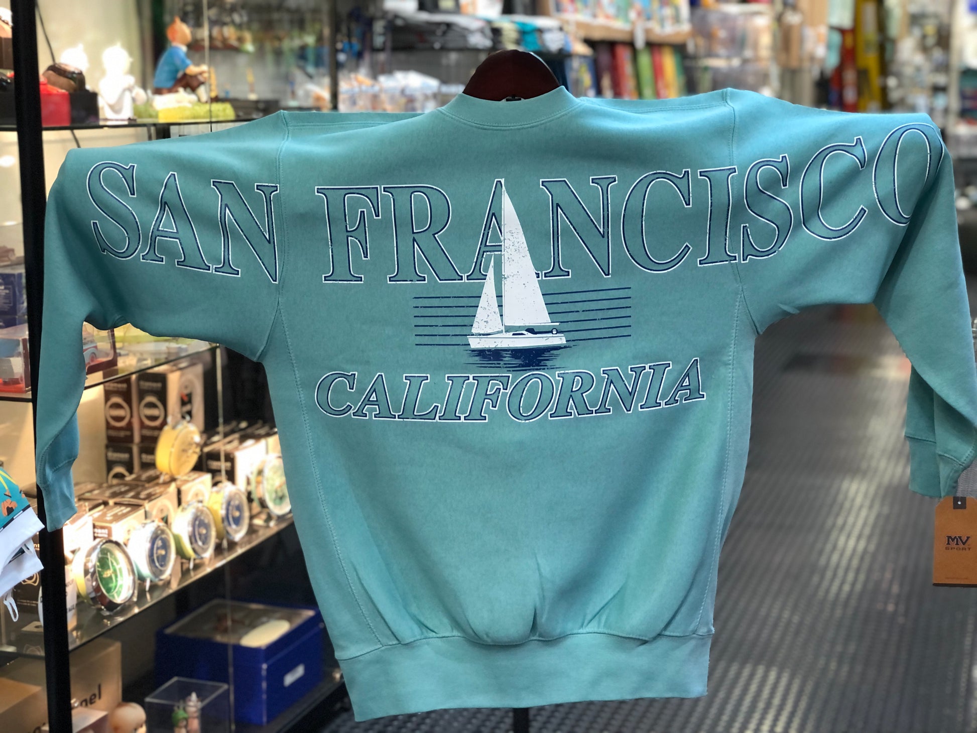 Teal sweatshirt with 'San Francisco California' text across the chest and arms and sailboat graphic.