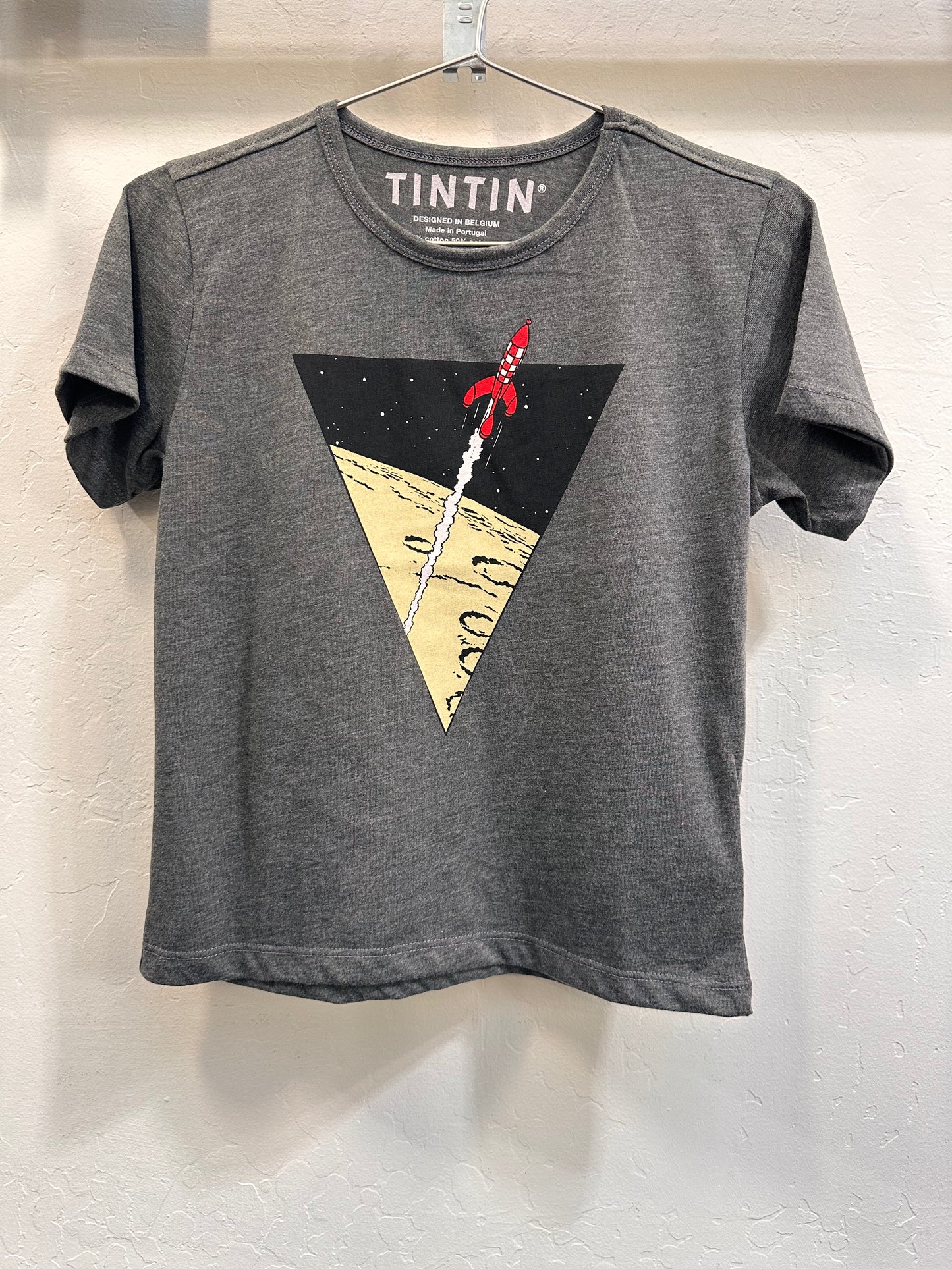 Grey Tintin kids t-shirt with triangle rocket design, showing red rocket launching from moon surface into starry space