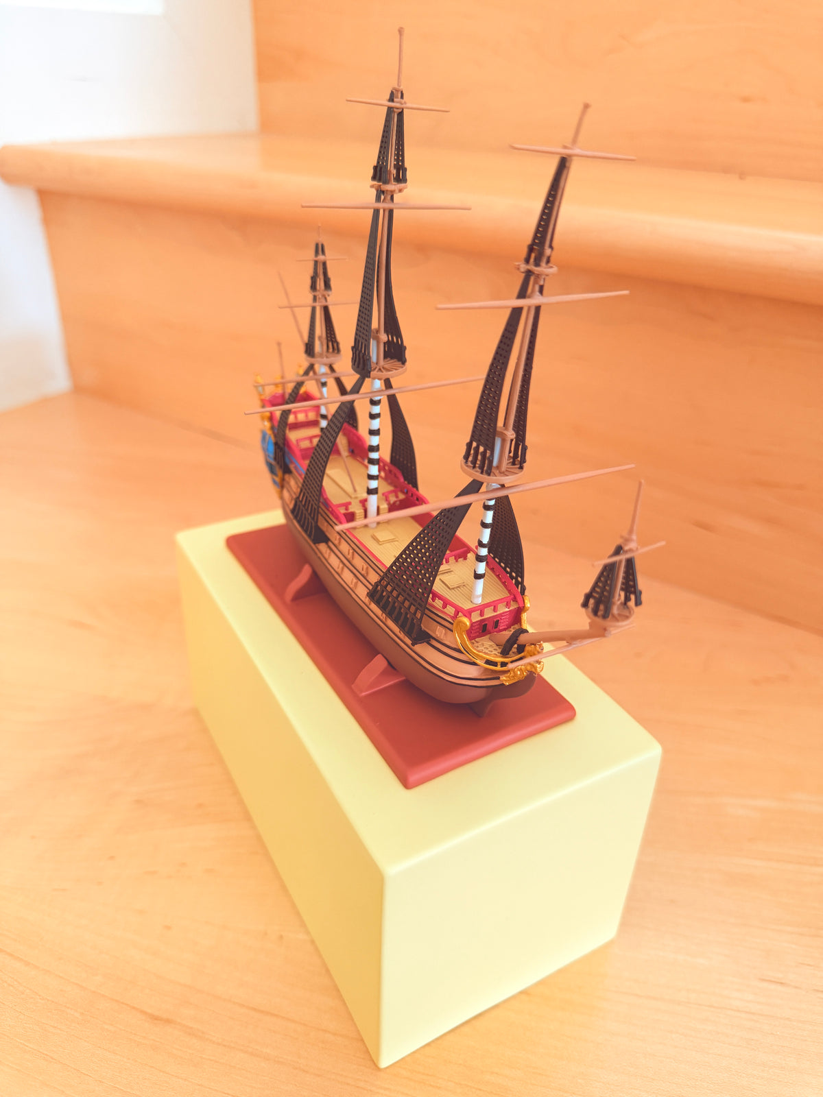 Angled front view of The Unicorn collectible model ship from The Adventures of Tintin, showing its detailed bowsprit, multi-tiered rigging, and red display base inside the Shopify admin panel.