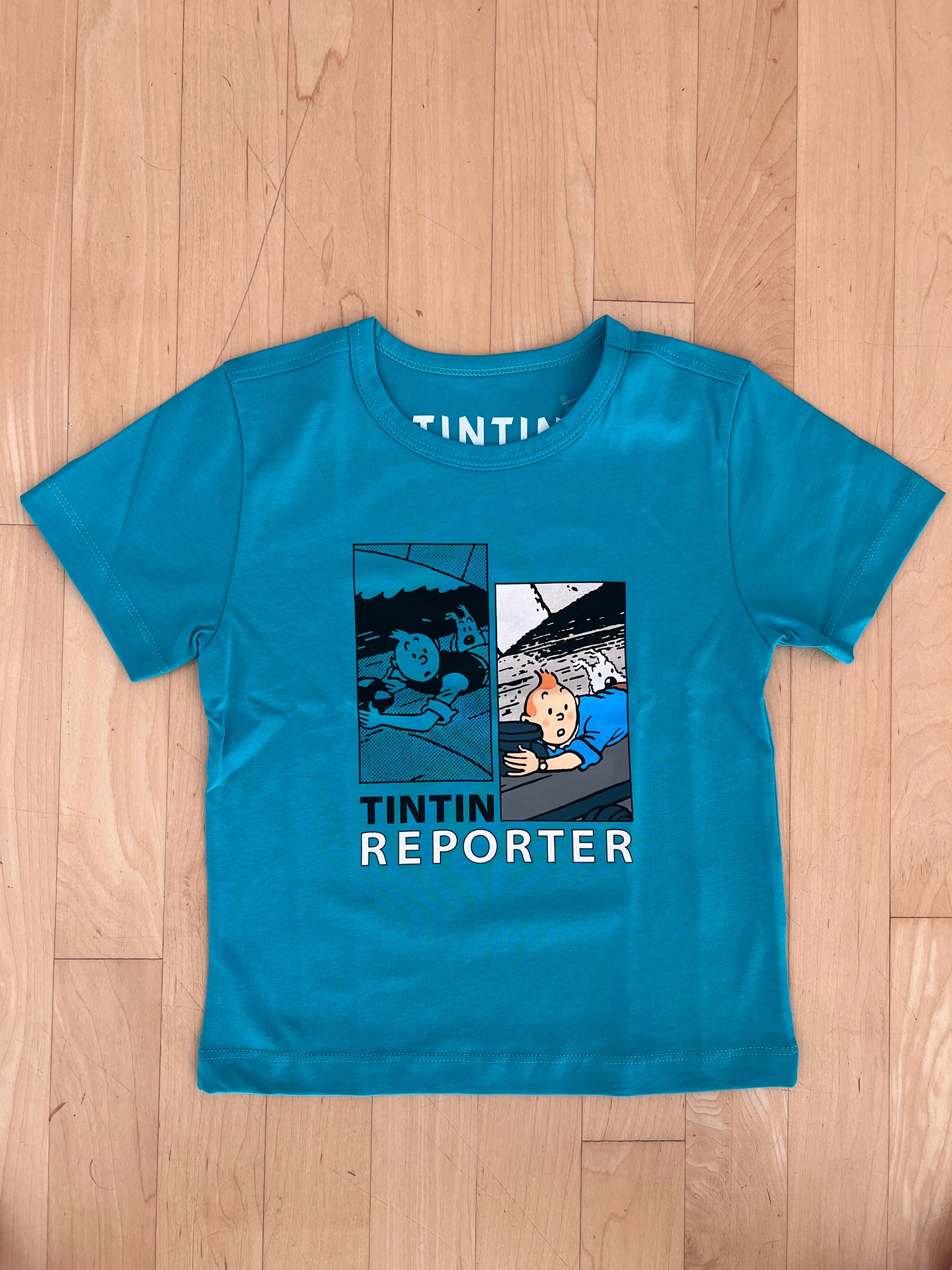 Turquoise kids' Tintin t-shirt with comic panels showing Tintin on train roof, 'Tintin Reporter' text