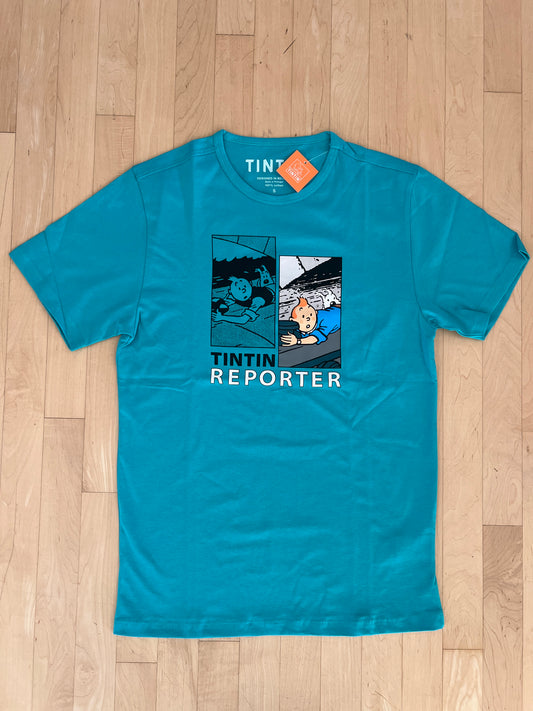 Turquoise Tintin Reporter t-shirt with comic panels showing character on train roof, laid on wooden floor