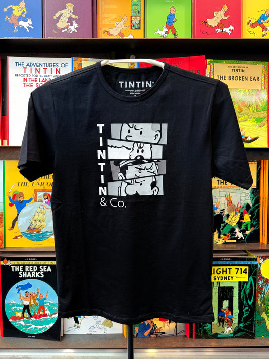 A front view of a black unisex t-shirt displayed against a background of colorful Tintin comic book spines. The t-shirt features a white graphic design on the chest composed of four stacked rectangular comic panels displaying close-ups of Tintin and Snowy, with the vertical text "TINTIN" stacked to the left and "& Co." printed cleanly underneath.