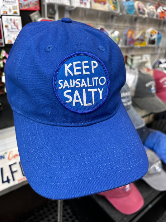 Keep Sausalito Salty Blue Unstructured 100% Cotton Twill Cap featuring a circular "Keep Sausalito Salty" embroidered patch on a royal blue fabric crown.
