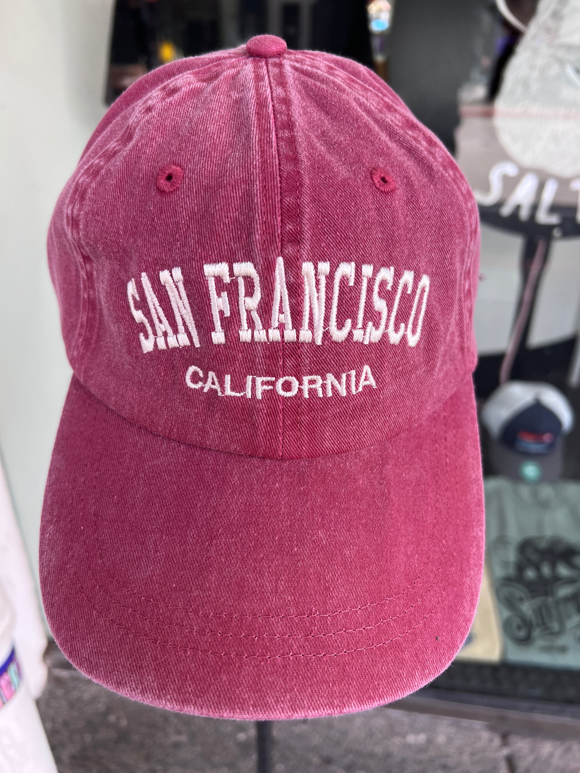 Front view of a wine red washed cotton baseball cap featuring the words 'San Francisco' in a bold white arched font with 'California' embroidered directly underneath.