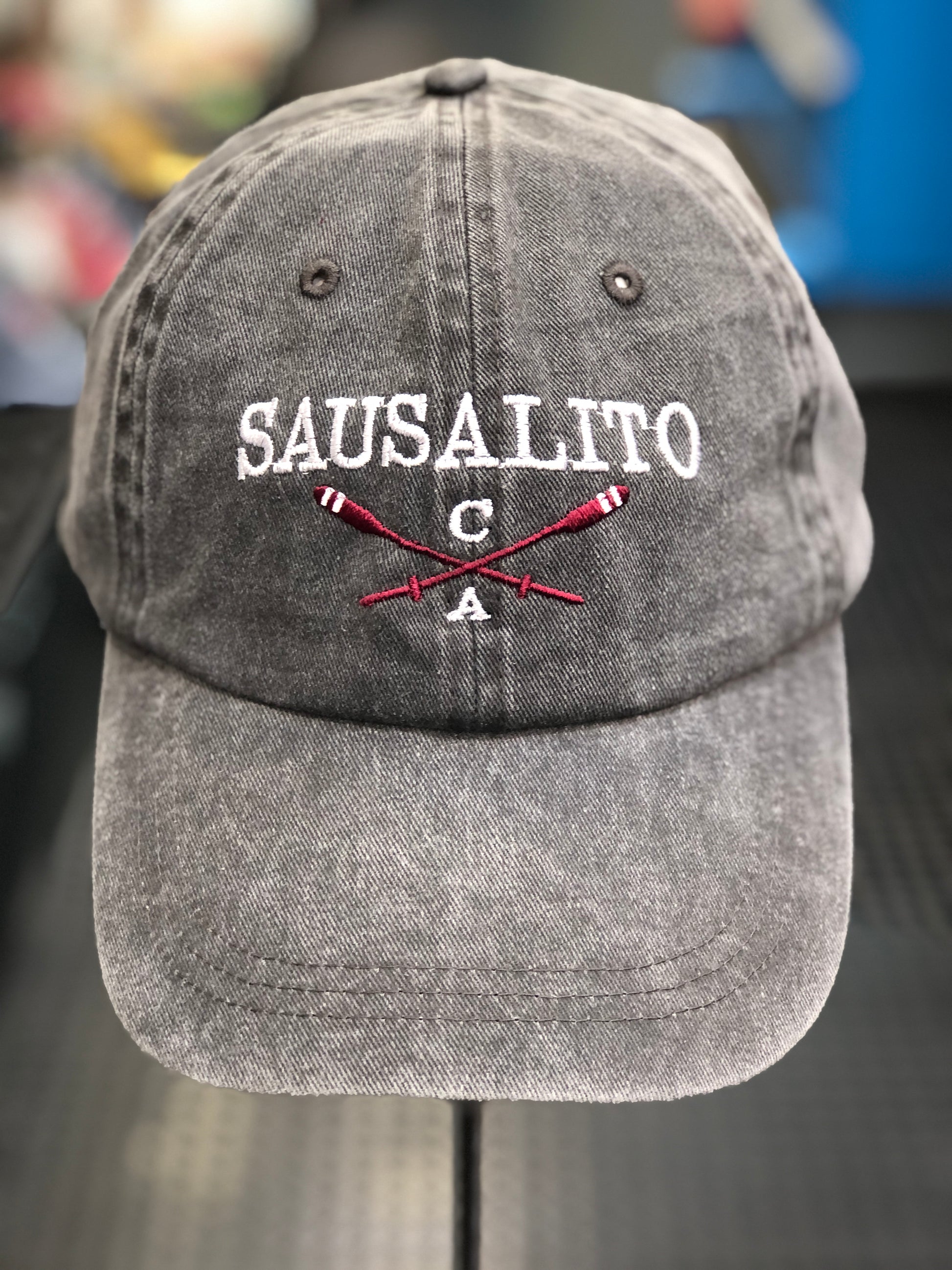 Charcoal grey washed cotton cap featuring embroidered "SAUSALITO CA" text and crossed red rowing oars.