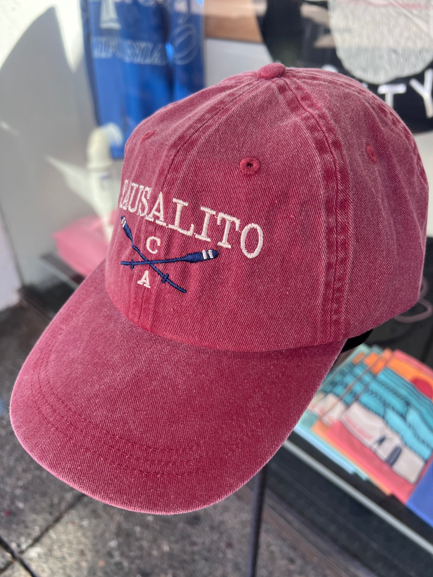 Maroon red washed cotton cap featuring embroidered "SAUSALITO CA" text and crossed blue rowing oars.
