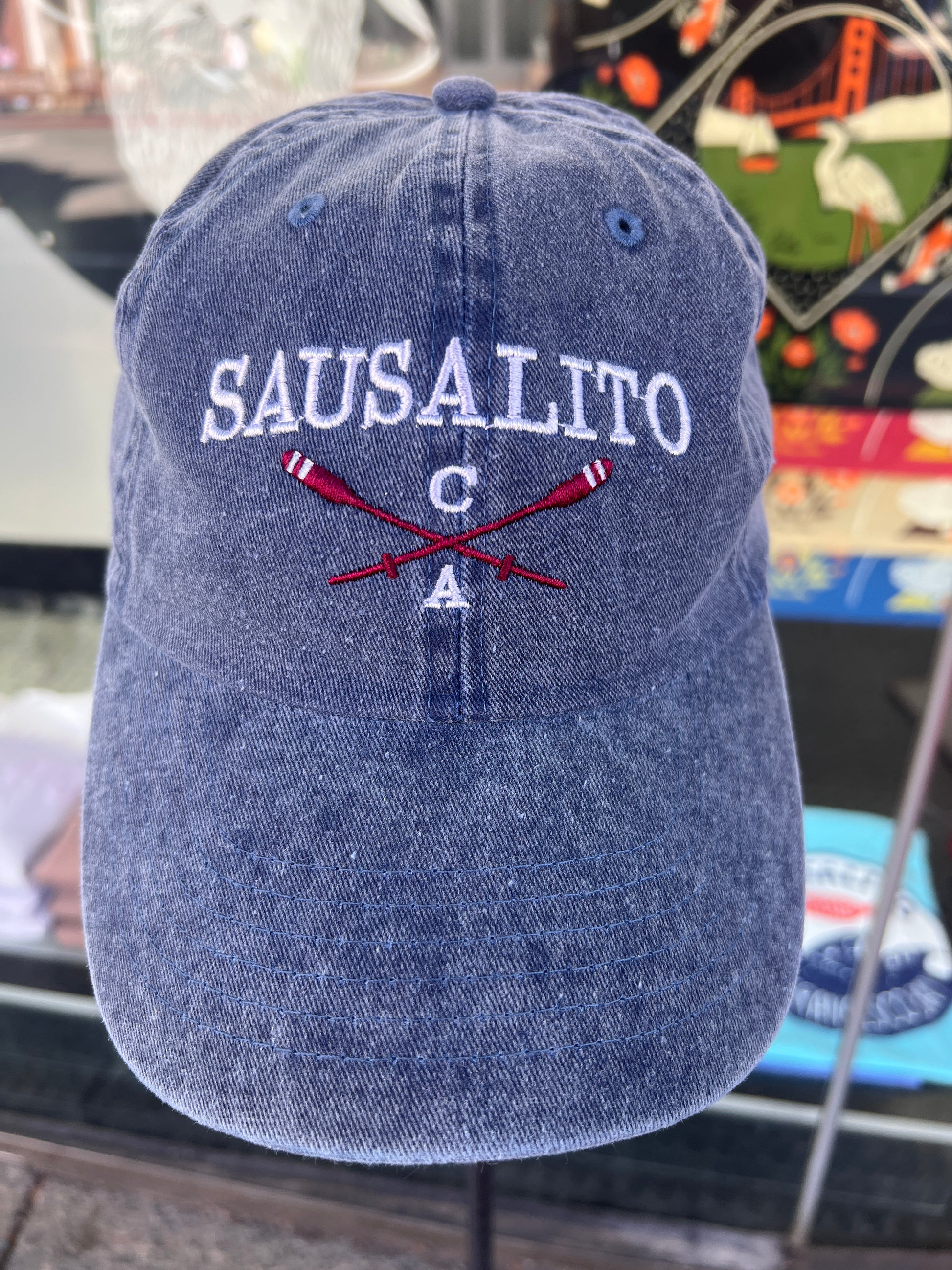 Royal blue washed cotton cap featuring embroidered "SAUSALITO CA" text and crossed red-and-white rowing oars.