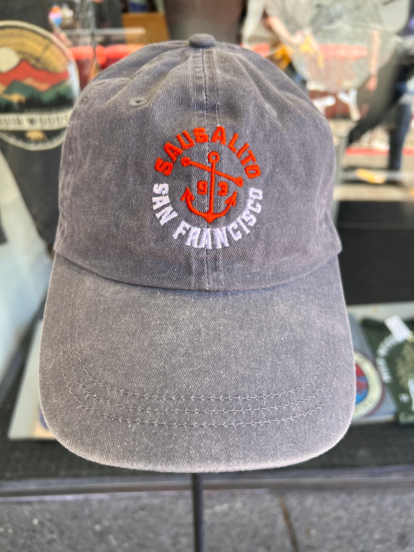 Front view of a vintage grey washed cotton baseball cap featuring an embroidered orange anchor with Sausalito and San Francisco text and the incorporation year 1893.