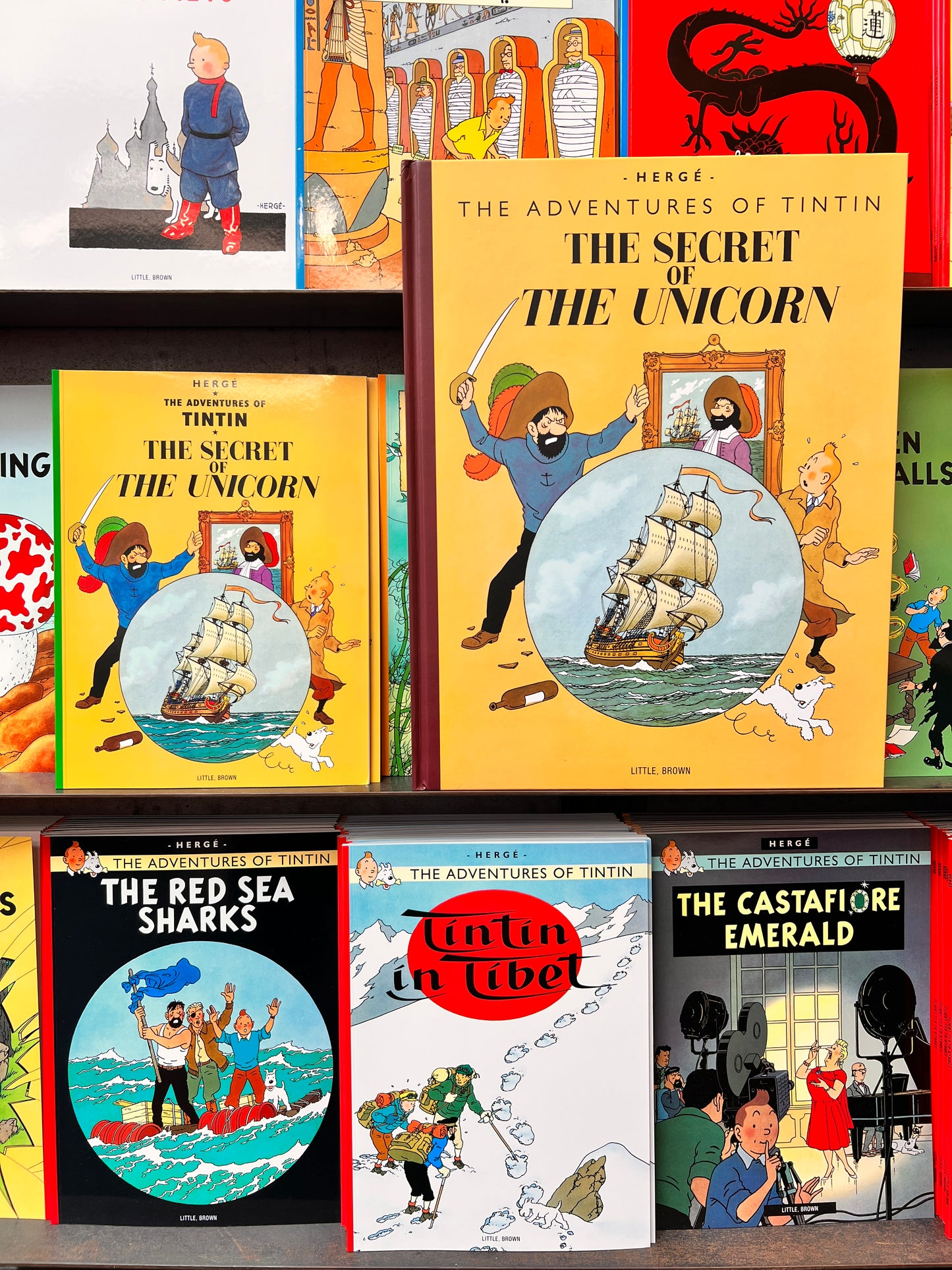 A close-up of the 1946 facsimile edition of 'The Secret of the Unicorn' by Hergé. The cover features Tintin, Snowy, and a pirate ancestor surrounding a circular illustration of the Unicorn sailing ship.