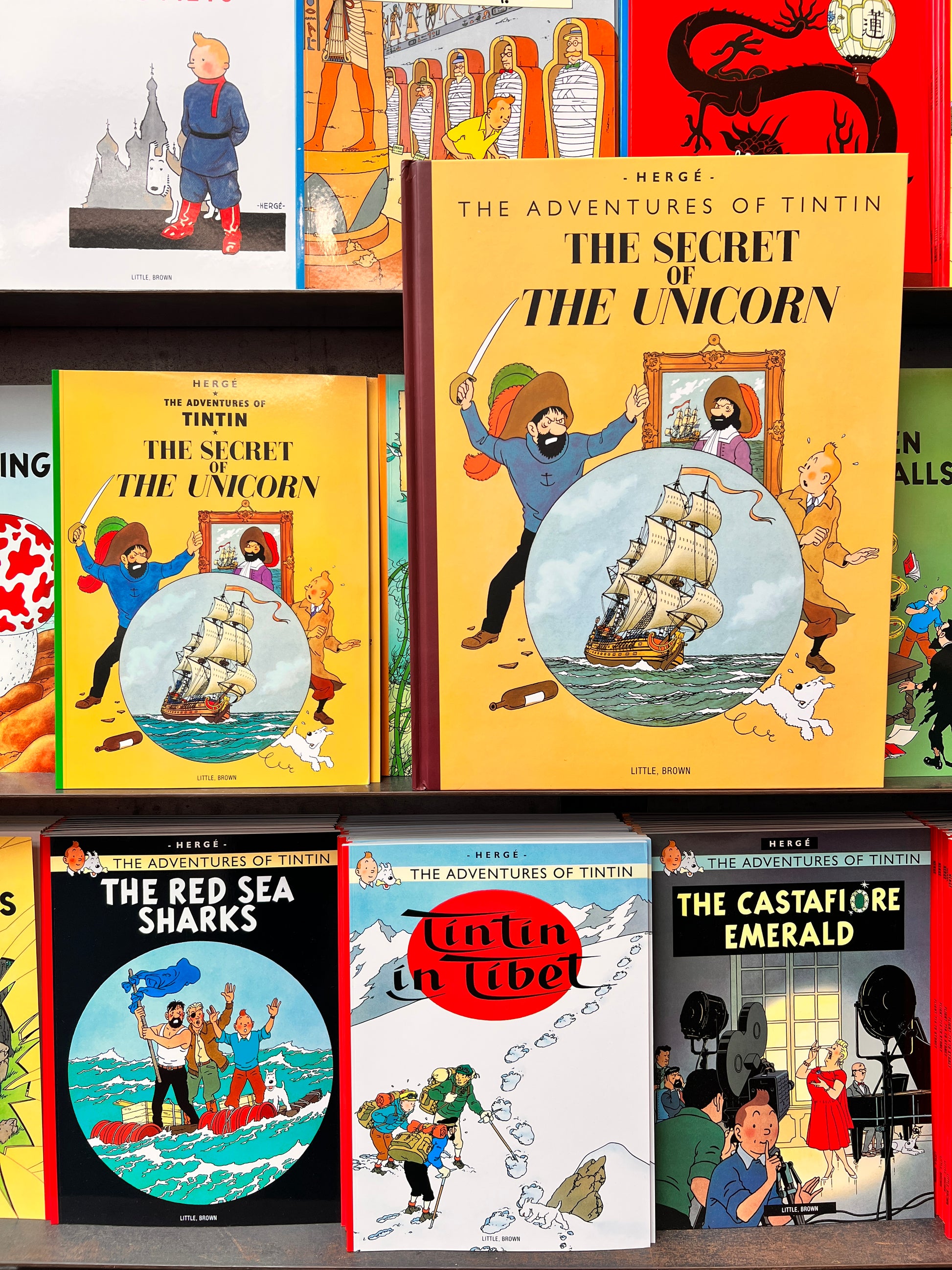 A close-up of the 1946 facsimile edition of 'The Secret of the Unicorn' by Hergé. The cover features Tintin, Snowy, and a pirate ancestor surrounding a circular illustration of the Unicorn sailing ship.