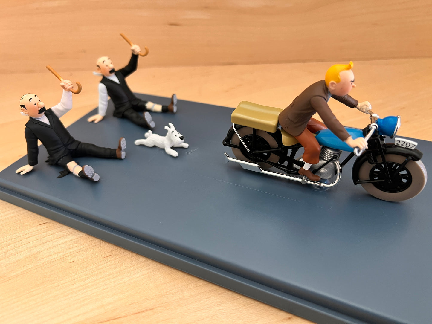 Hand-painted resin model of Tintin on a blue motorcycle speeding away from Thomson, Thompson, and Snowy. From the Syldavian chase in King Ottokar’s Sceptre.