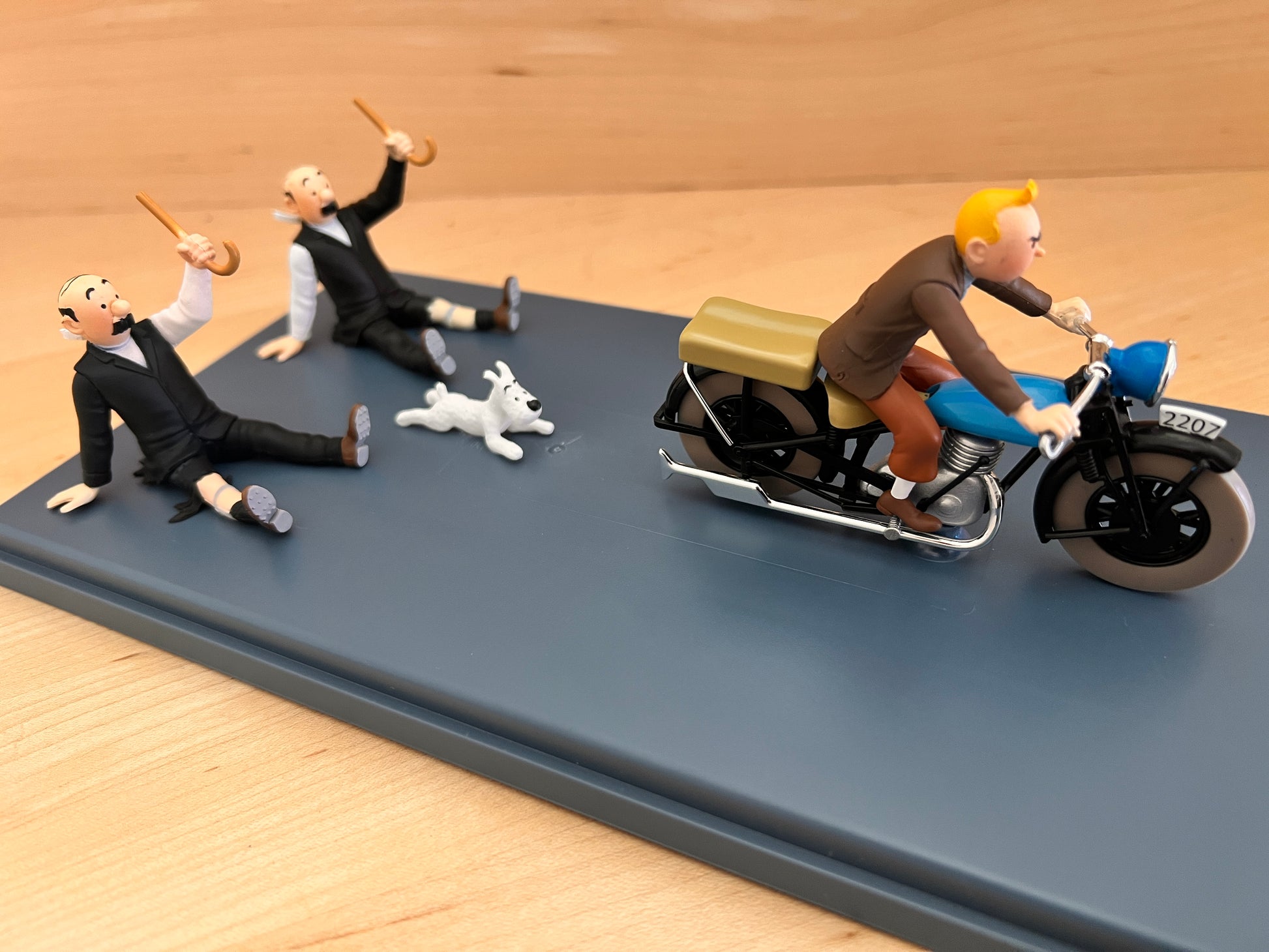 Hand-painted resin model of Tintin on a blue motorcycle speeding away from Thomson, Thompson, and Snowy. From the Syldavian chase in King Ottokar’s Sceptre.