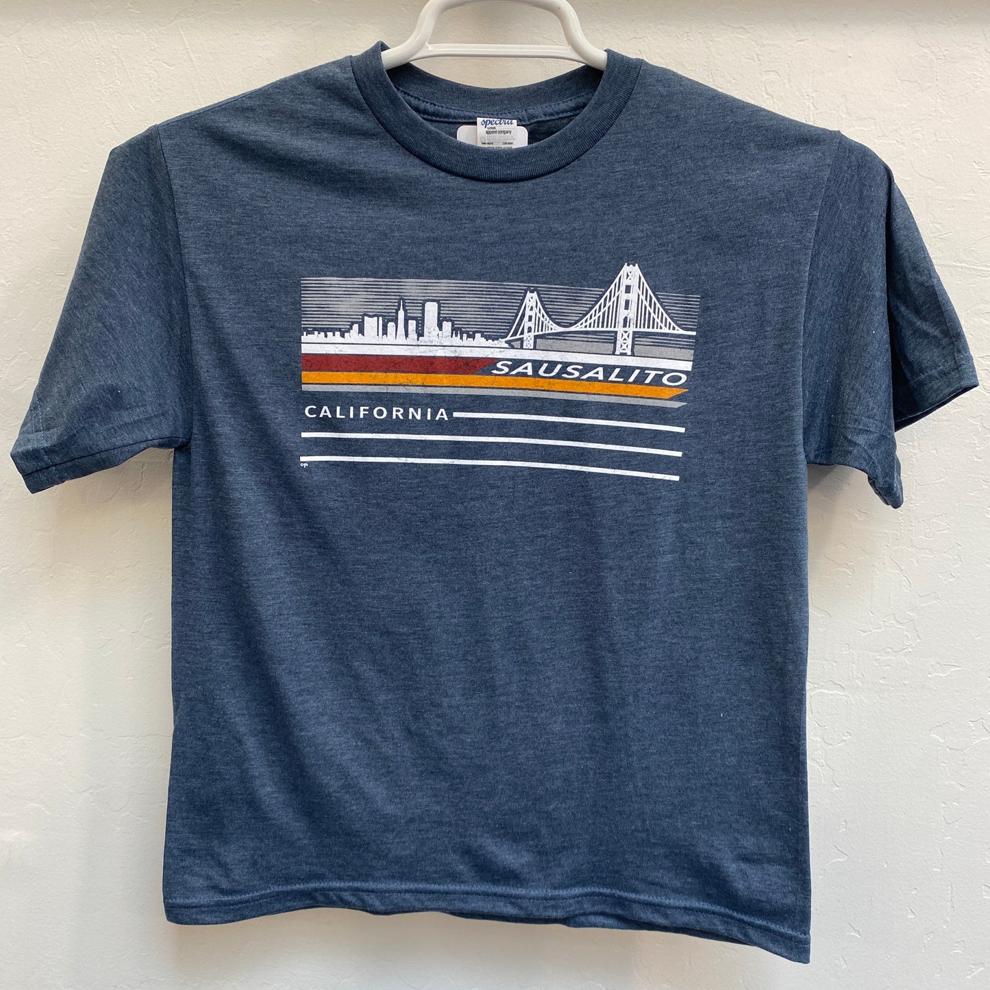 Navy kids' t-shirt with Sausalito California skyline and Golden Gate Bridge graphic, hanging on display