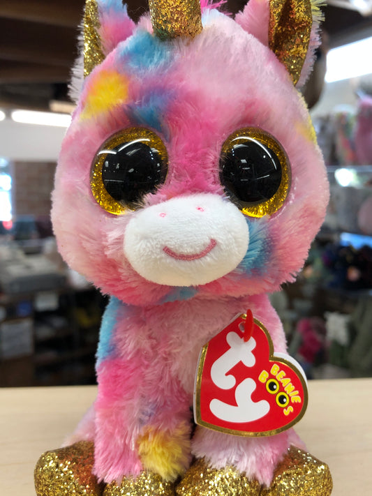 Colorful Ty Beanie Boo Fantasia unicorn plush toy with sparkly gold eyes, horn, and hooves, featuring pink, blue, and yellow fur
