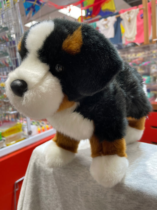 Realistic Bernese Mountain Dog plush toy with tri-color coat, soft fur, and lifelike features on display in colorful toy store