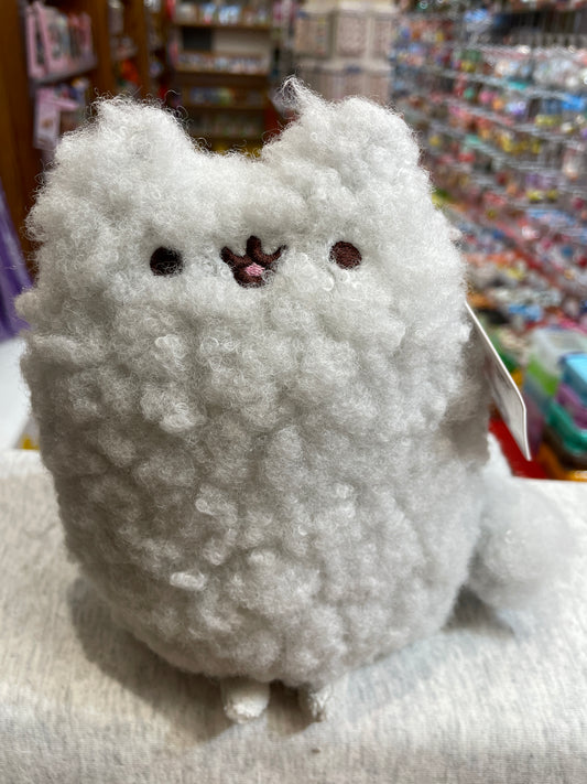Fluffy white Gund Pusheen Stormy plush toy with cute embroidered face, displayed in toy store setting