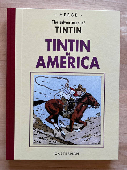 Tintin in America book cover, Casterman edition, featuring cowboy on galloping horse with lasso, by Hergé