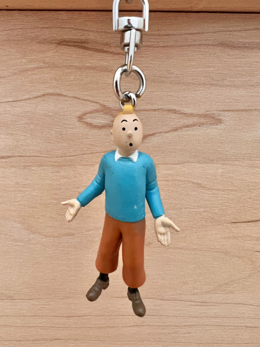 Tintin blue sweater keychain, 5.5cm PVC figure with metal chain, shown against wooden background