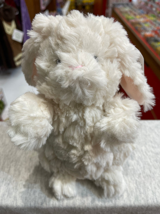 Soft, fluffy white Puttling Bunny plush toy with floppy ears and sweet smile, sitting on display in a store
