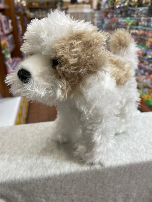 Adorable Maltipoo plush dog with fluffy white and tan fur, standing upright in a toy store display