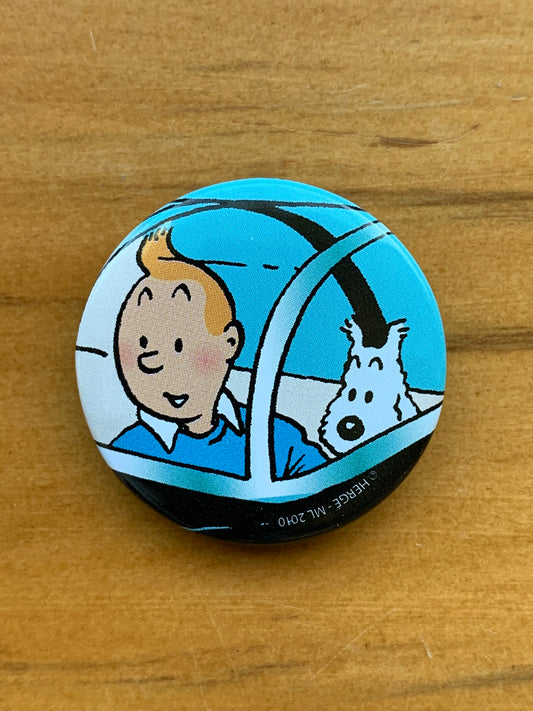 Tintin and Snowy in shark submarine button from Red Rackham's Treasure, 3.3cm collectible pin on wooden surface
