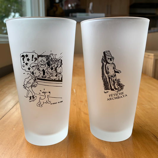 Tintin frosted glasses featuring antique store scene and Arumbaya Fetish, collectible tableware from The Broken Ear adventure