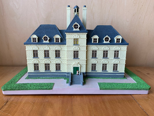 Detailed model of Marlinspike Hall, Captain Haddock's chateau from Tintin, with cream walls, blue roof, and manicured grounds