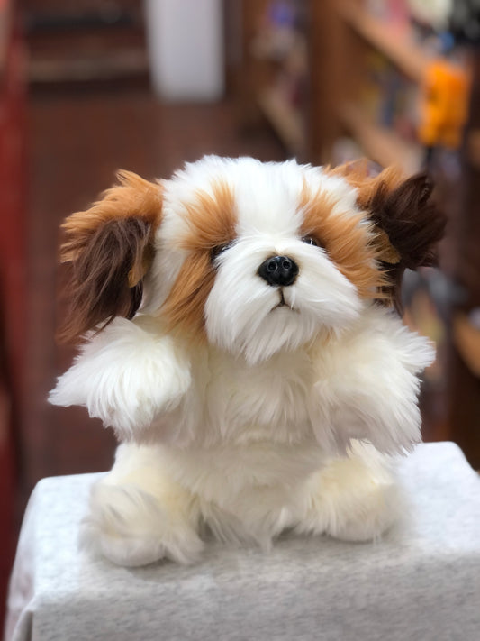 Adorable brown and white dog puppet with fluffy fur and expressive face, sitting upright on display
