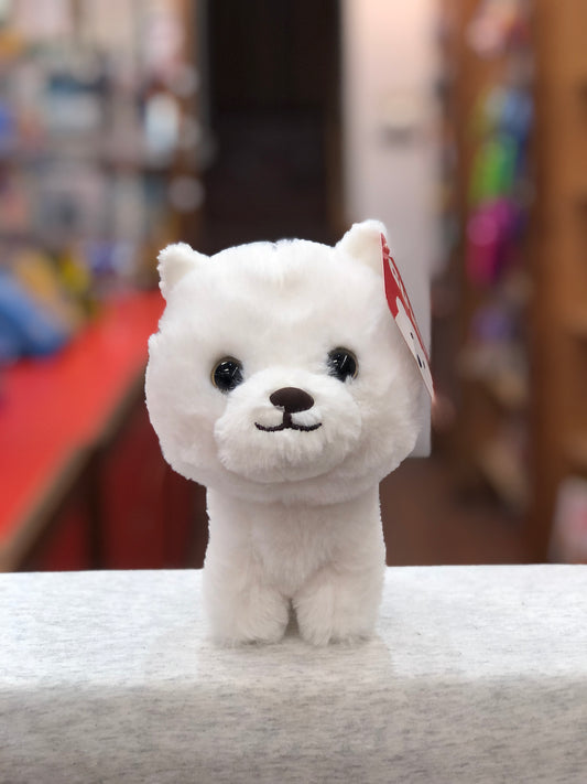 Adorable white Gund Westie puppy plush toy with big eyes and smiling face, sitting on display in a toy store