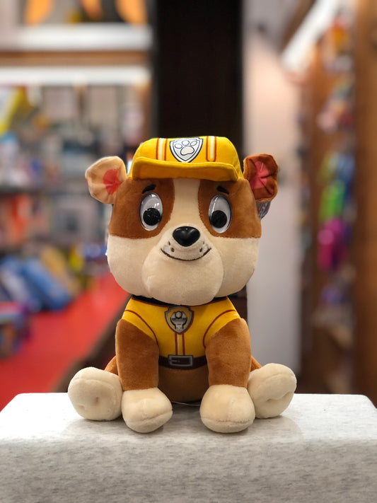 Gund Paw Patrol Rubble plush toy in yellow construction uniform, sitting on display in toy store