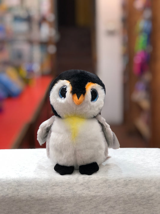 Ty Beanie Babies Pongo penguin plush toy with blue glittery eyes, black and white fur, and orange beak on white surface