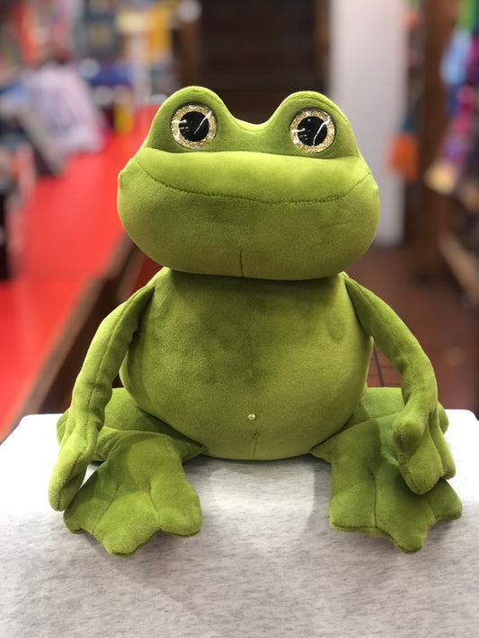 Adorable green frog plush toy with glittery gold eyes, sitting on display with floppy arms and legs