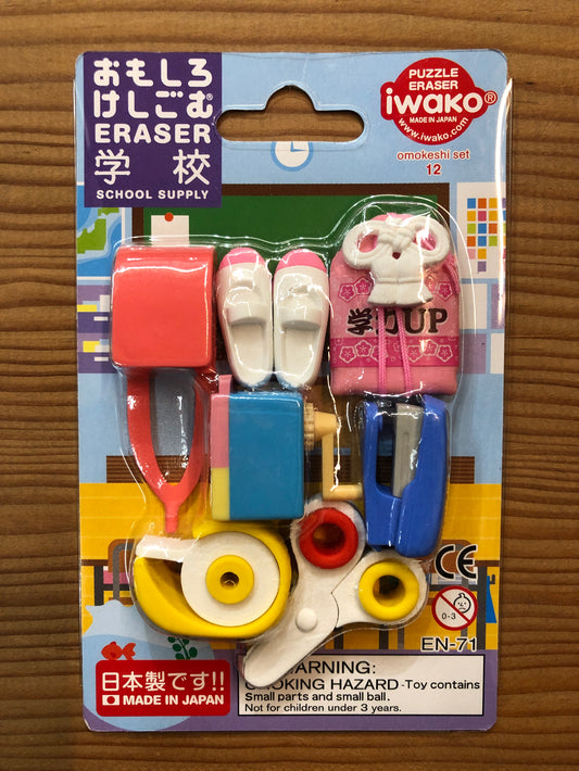 Japanese school supply eraser set with miniature backpack, shoes, scissors, stapler, and other items, packaged in colorful cardboard backing