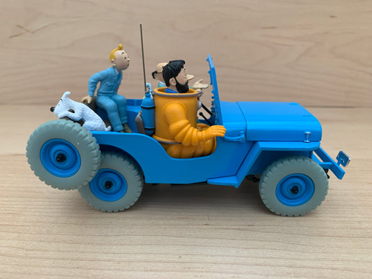 Tintin Blue Jeep CJ2A model from Destination Moon, 1/24 scale, with characters and dog figurines, displayed on wooden surface