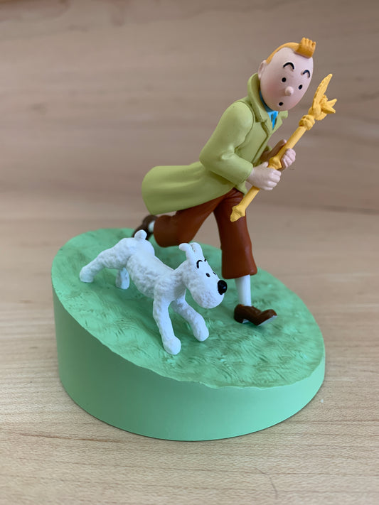 Tintin figure holding King Ottokar's Scepter, running with Snowy on green base, collectible Moulinsart figurine