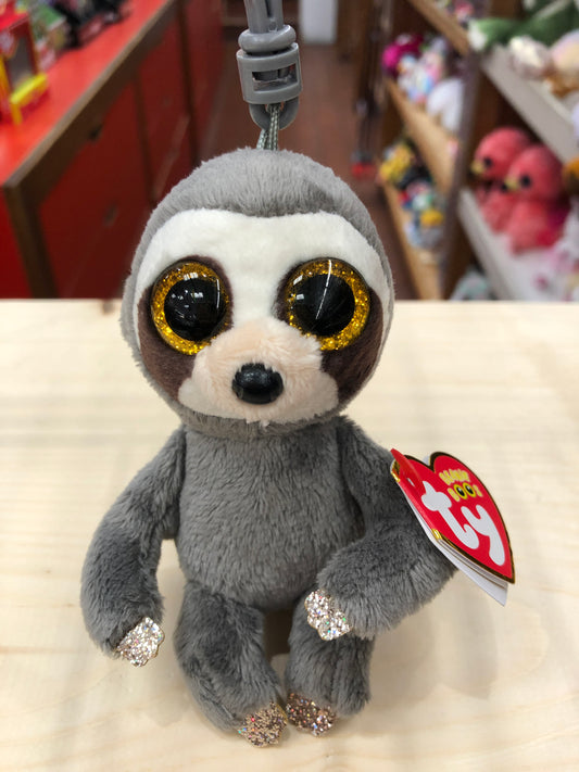 Ty Beanie Boo Dangler sloth plush clip with sparkly golden eyes, soft gray fur, and glittery paws on display in toy store