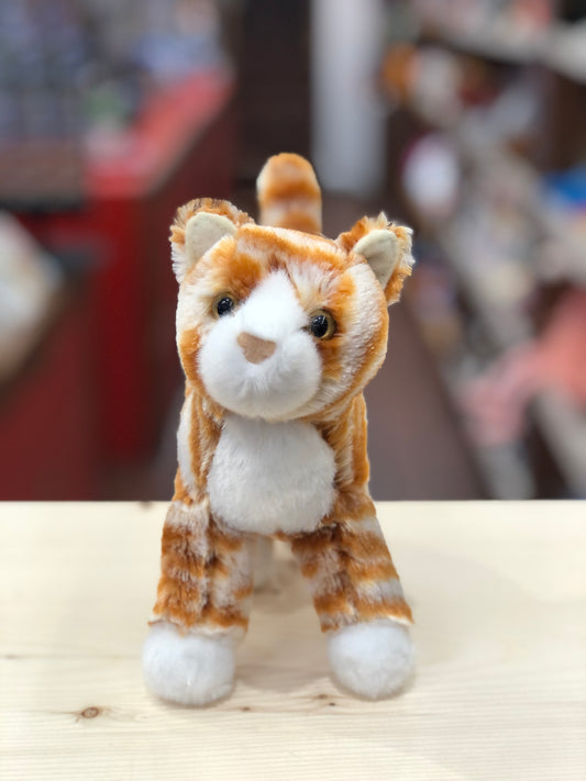 Adorable orange striped cat plush toy Hally sitting upright, with bright eyes and white paws, ready for adventure