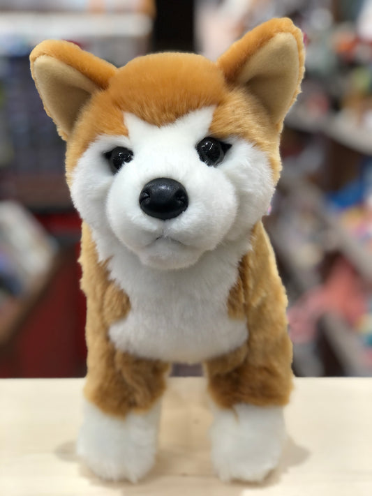Adorable Shiba Inu plush toy with realistic features, golden-orange fur, and expressive face, standing upright on display