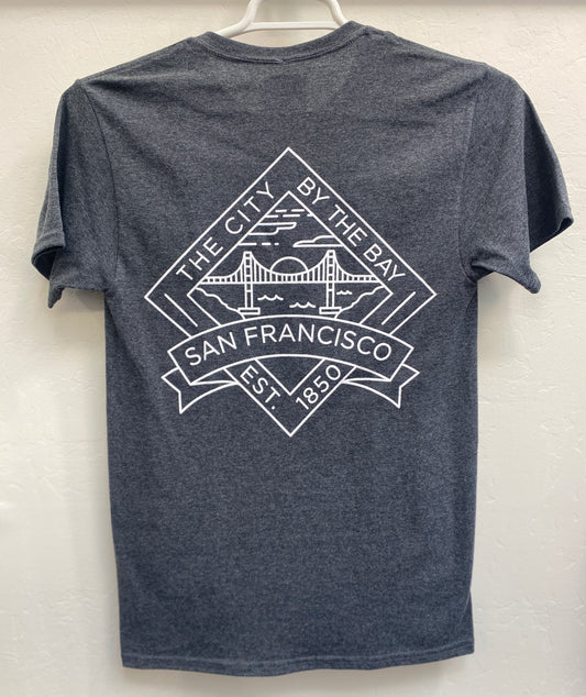 Back view of a charcoal gray heathered crewneck t-shirt hanging on a white plastic hanger. The shirt features a large, crisp white geometric graphic screen-printed across the upper back. The design is a diamond-shaped crest containing a minimalist outline of the Golden Gate Bridge under a setting sun over the bay, framed by the arched text "THE CITY BY THE BAY" on top, "SAN FRANCISCO" on a bold ribbon banners across the center, and "EST. 1850" at the bottom point.